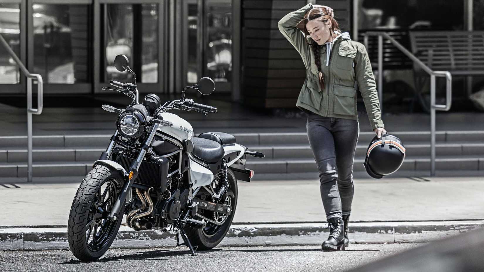 Uma motociclista se aproximando de um Kawasaki Eliminator branco