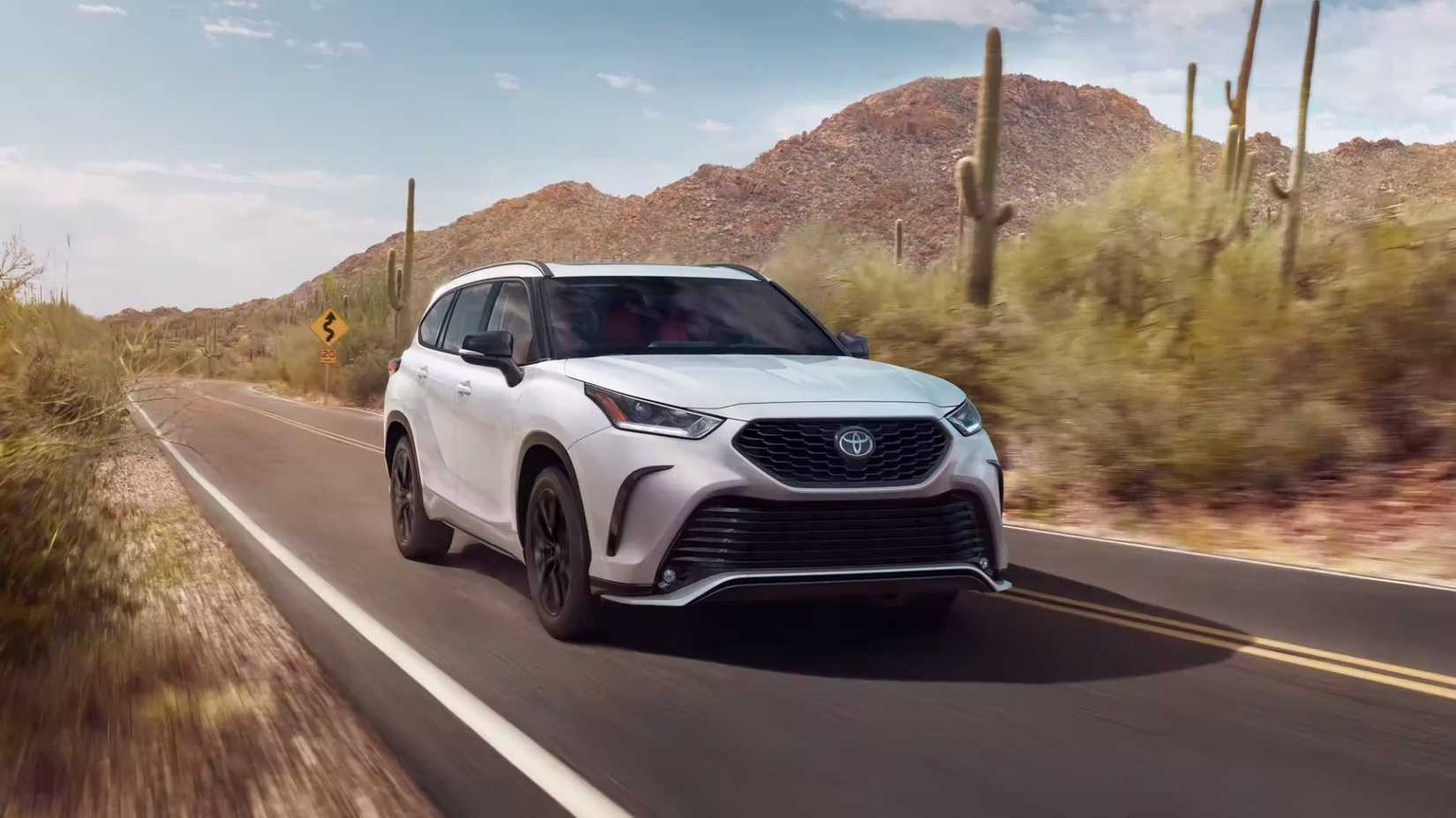 2023 Toyota Highlander Hybrid in white driving through desert