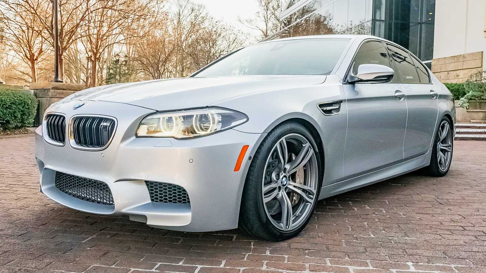 2015 BMW M5 frente 3/4 tiro estacionado na garagem