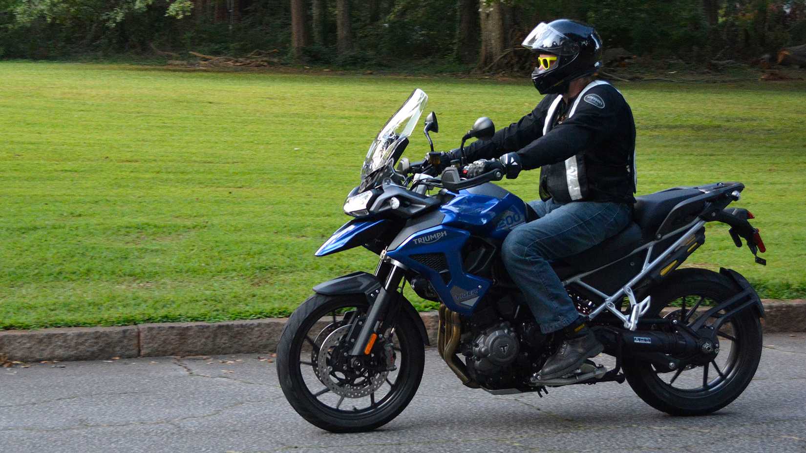 A man riding a 2023 Triumph Tiger 1200 GT Pro near a field.