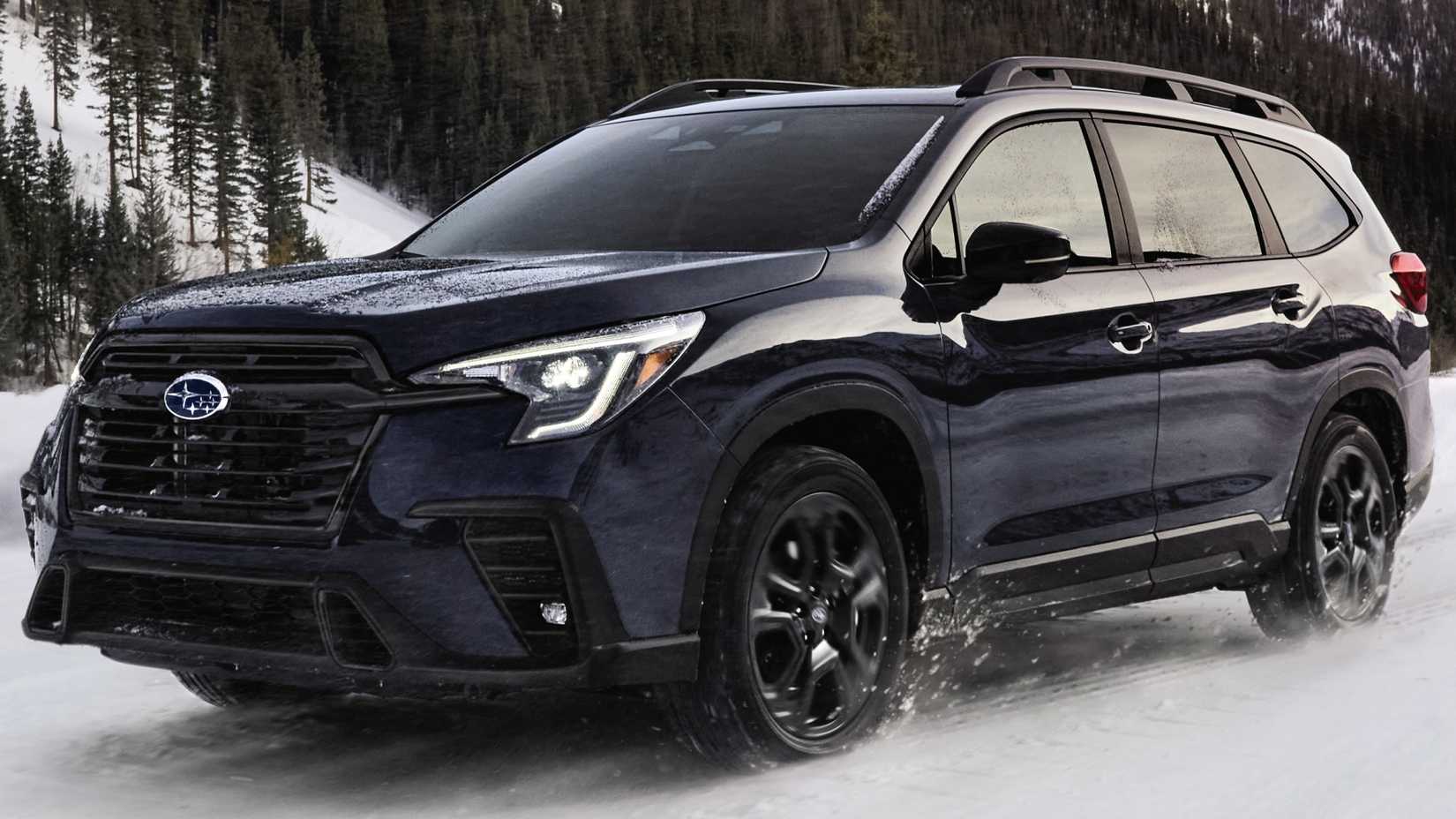 2024 Subaru Ascent driving on a snow-clad road with a mountain in the background