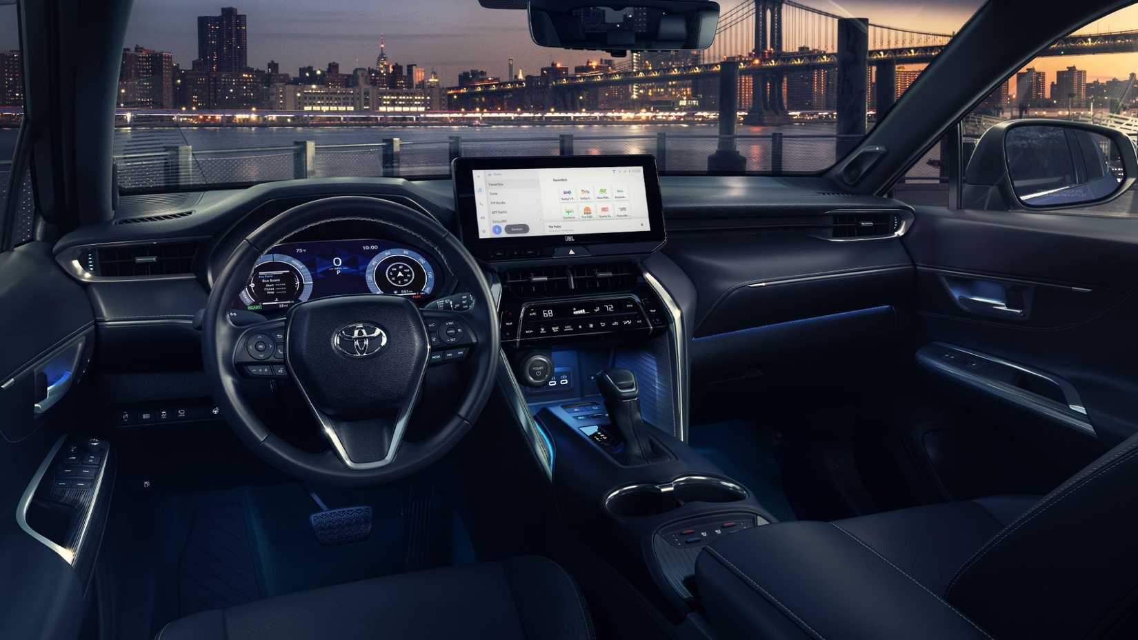 Foto do interior do Toyota Venza 2024 mostrando volante, coluna central e bancos dianteiros