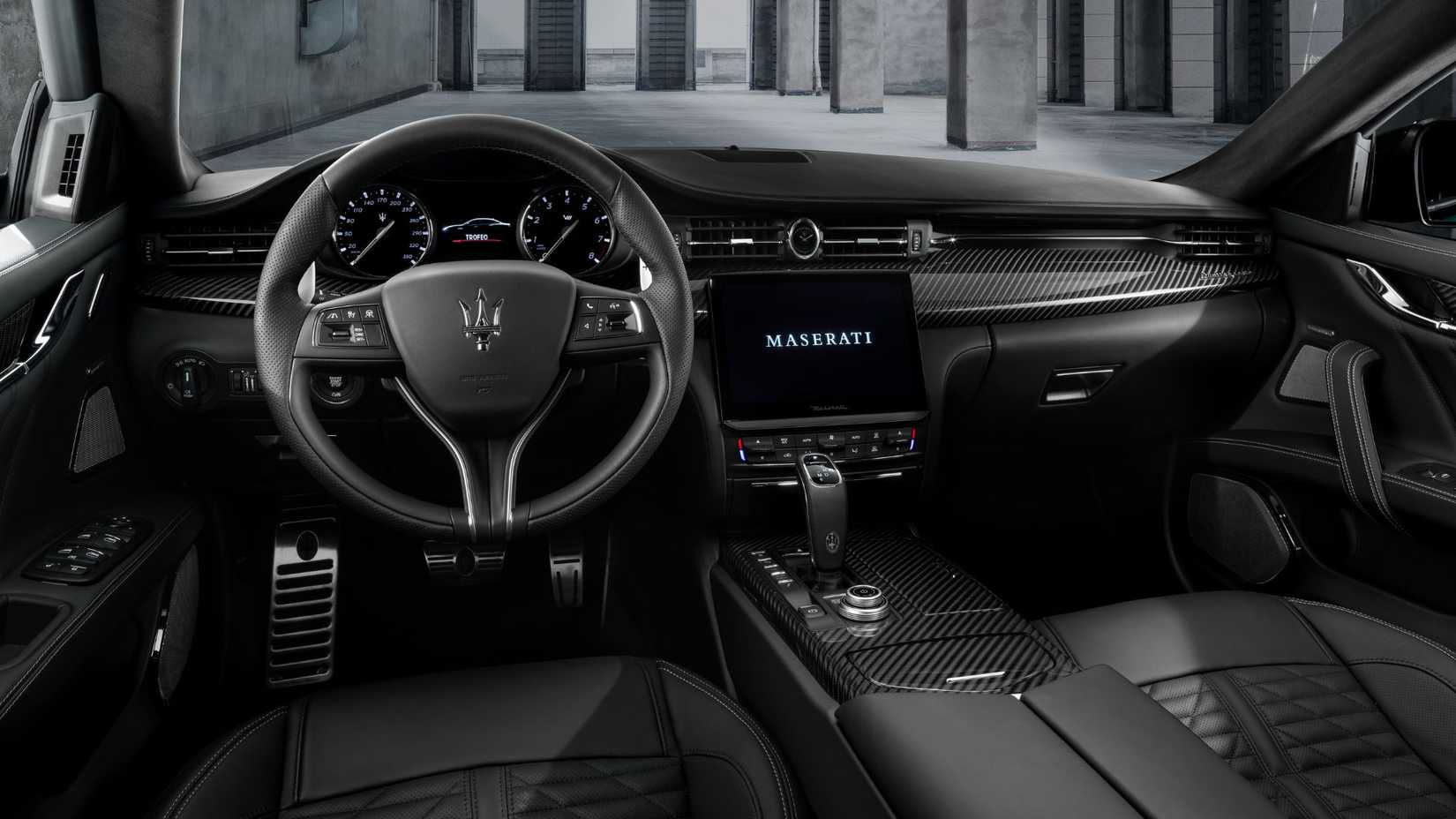 Foto do interior de um Maserati Quattroporte mostrando a cabine dianteira e o painel
