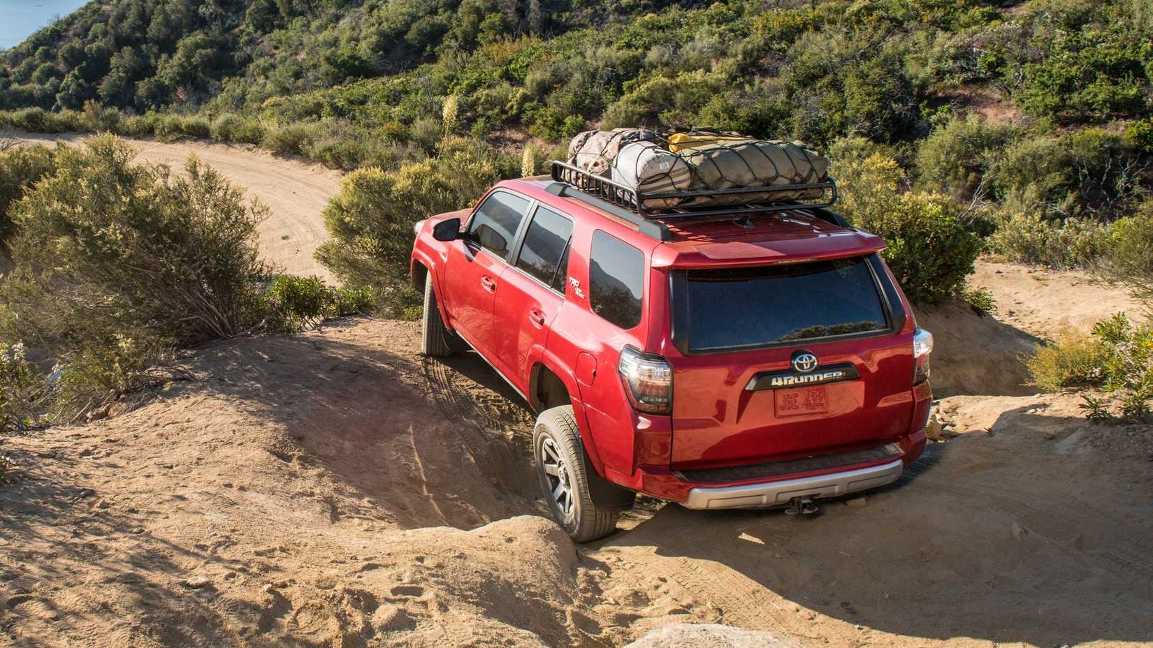 Rear actions shot of a red 2024 Toyota 4Runner off road in a desert