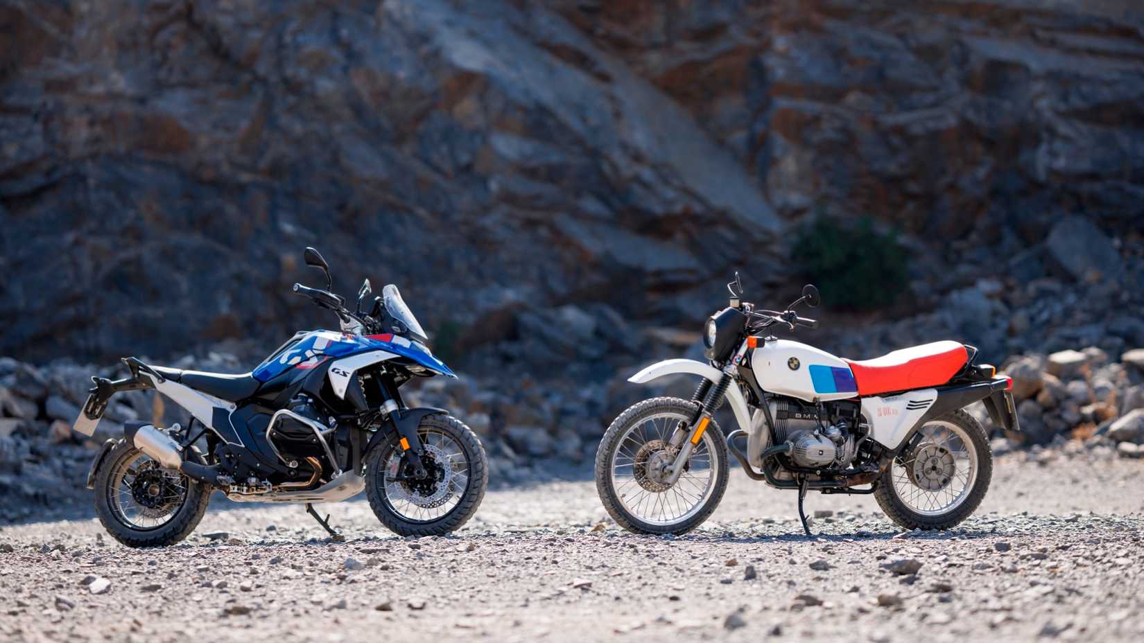 BMW R 80 G/S and BMW R 1300 GS facing each other off-road in front of a mountain