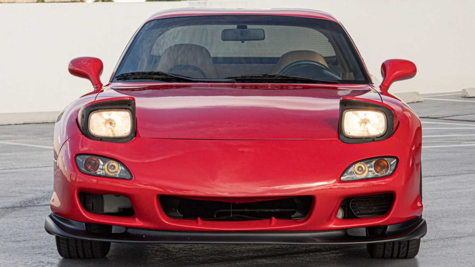 O Mazda RX-7 de 1993 tem acabamento em vermelho sobre estofamento em couro bege e é movido por um motor rotativo de 1,3 litros biturbo