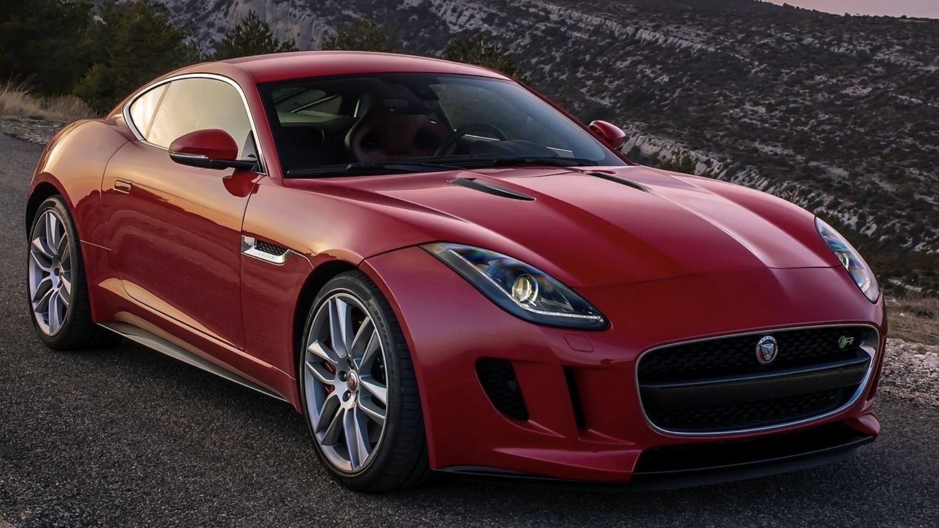 2015 Jaguar F-TYPE Coupe em vermelho posando em estrada de montanha