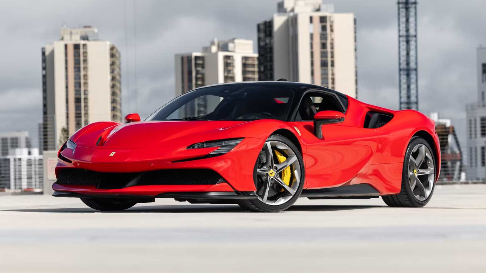 Uma Ferrari SF90 Stradale 2021 vermelha estacionada em frente ao horizonte