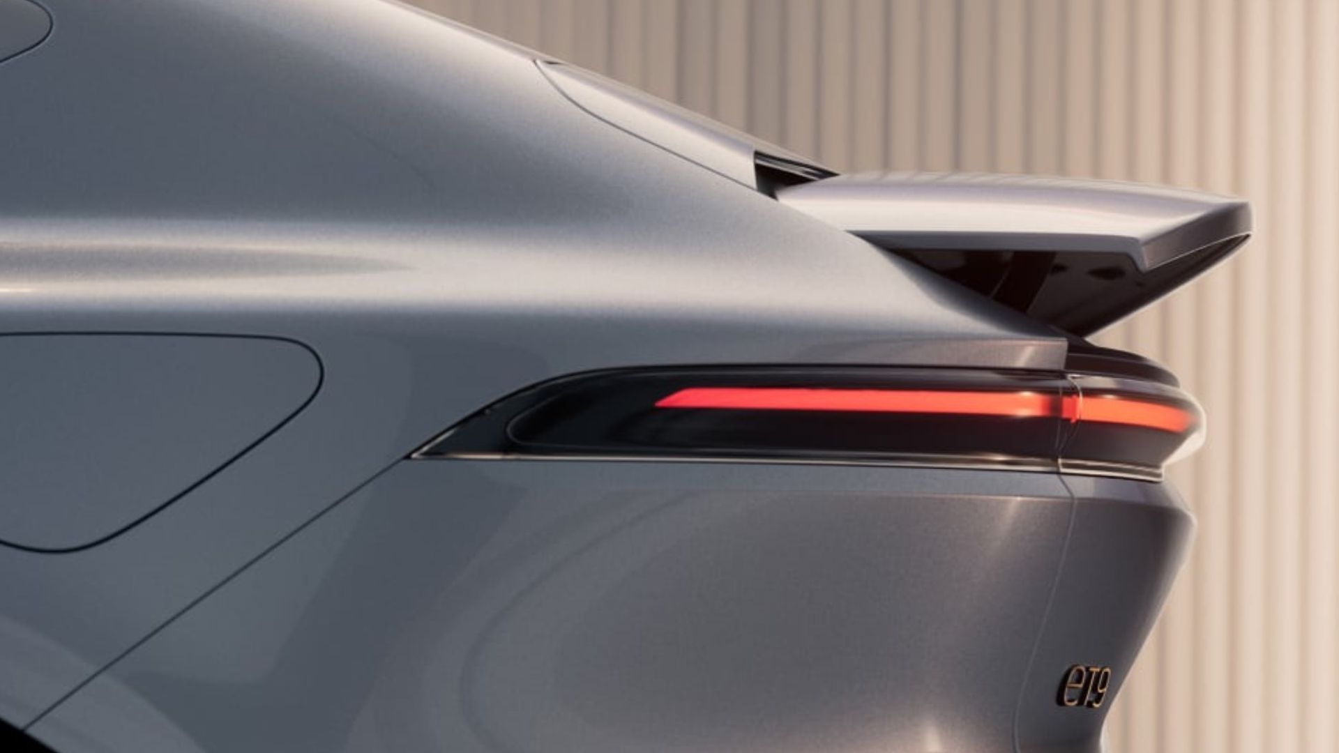 NIO ET9 rear three-quarter — the fastback silhouette and full-width light bar give it presence without aggression