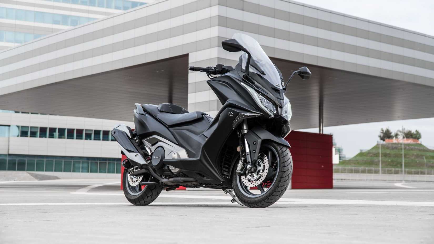 KYMCO AK 550i estacionado em frente a um prédio de escritórios