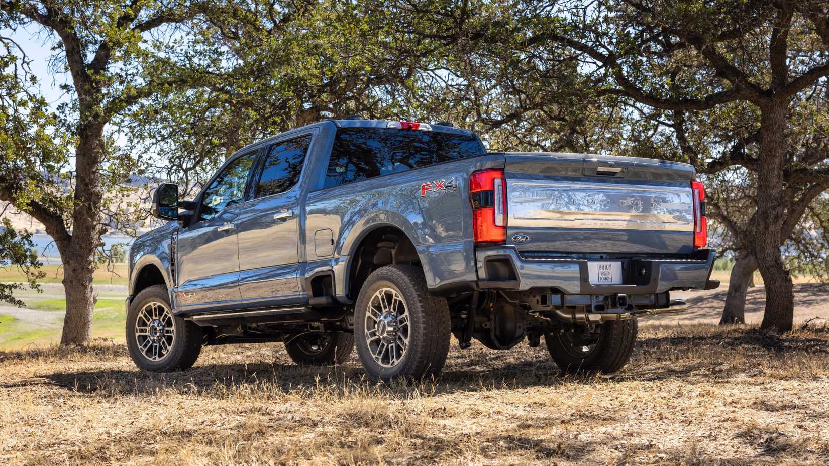 Foto traseira 3/4 de um Ford F-250 Super Duty 2023 azul estacionado fora de estrada