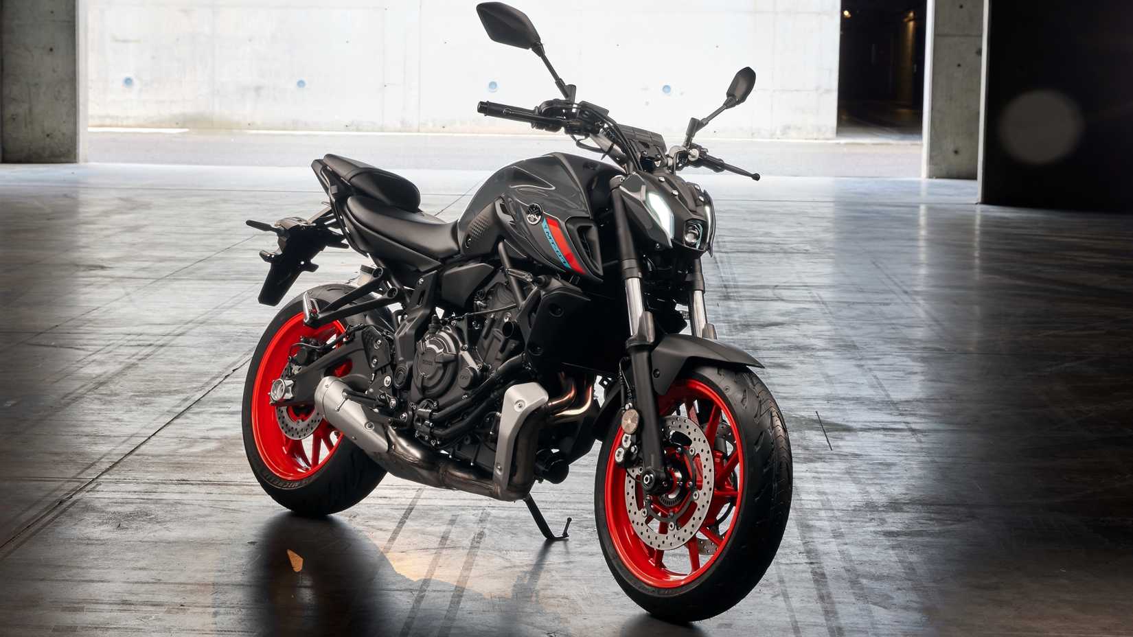 Yamaha MT-07 cinza e laranja 2021 estacionada dentro de casa