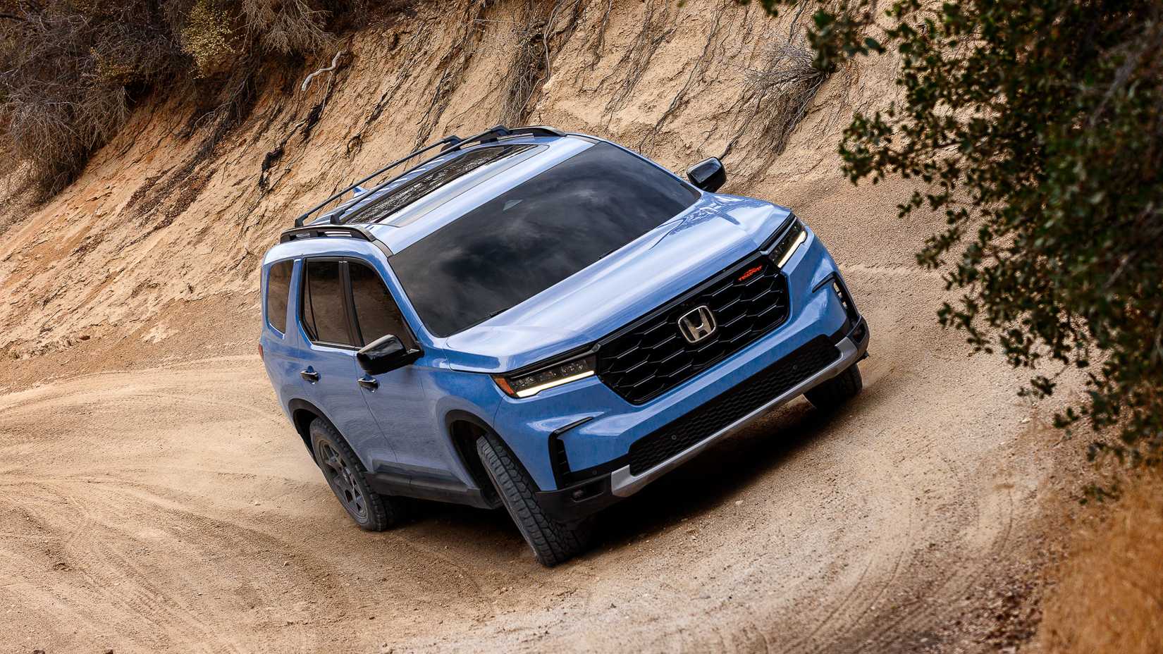2024 Honda Pilot, front quarter view, off-roading at angle, blue