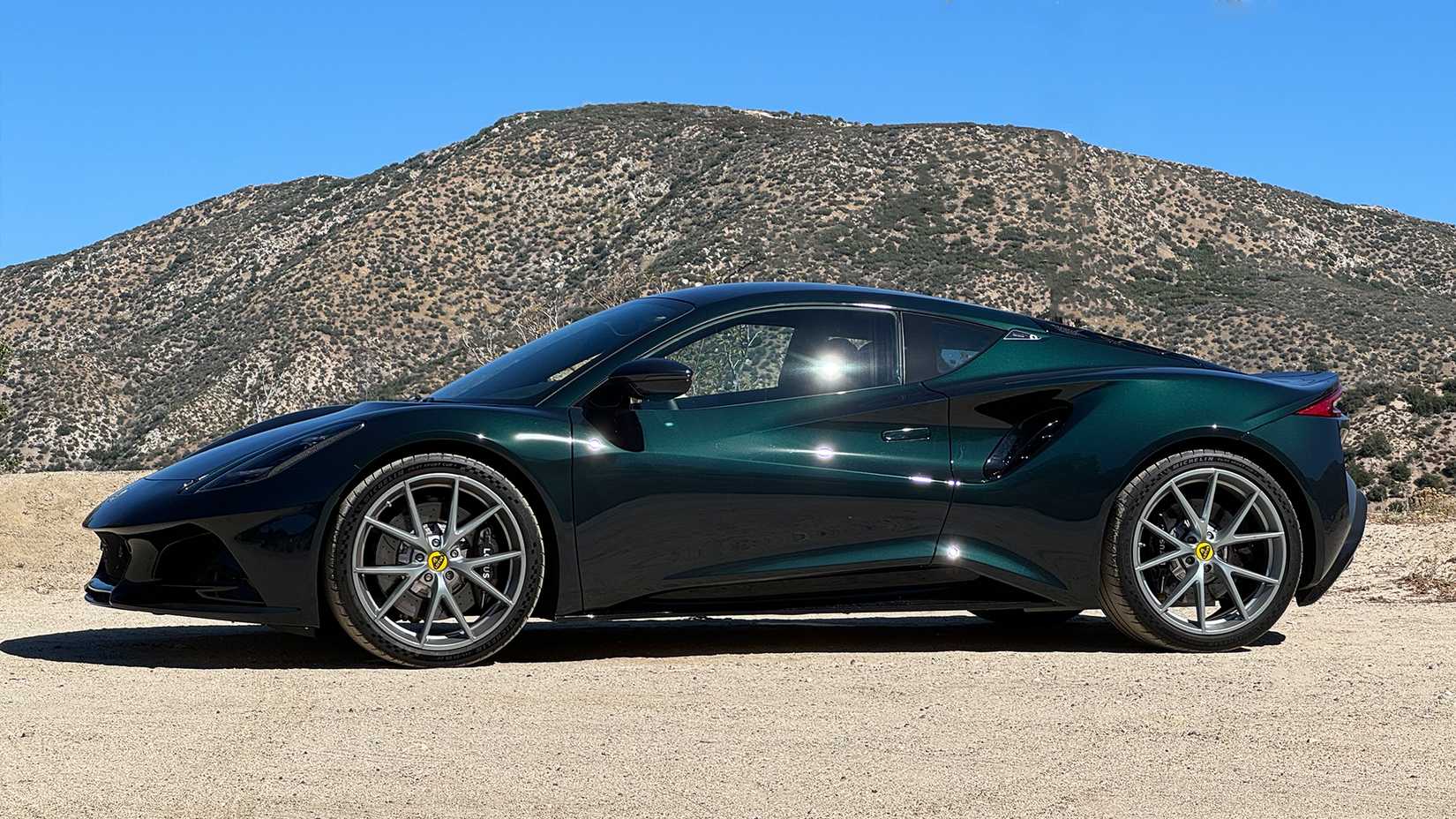 Side shot of a green 2024 green Lotus parked in dirt