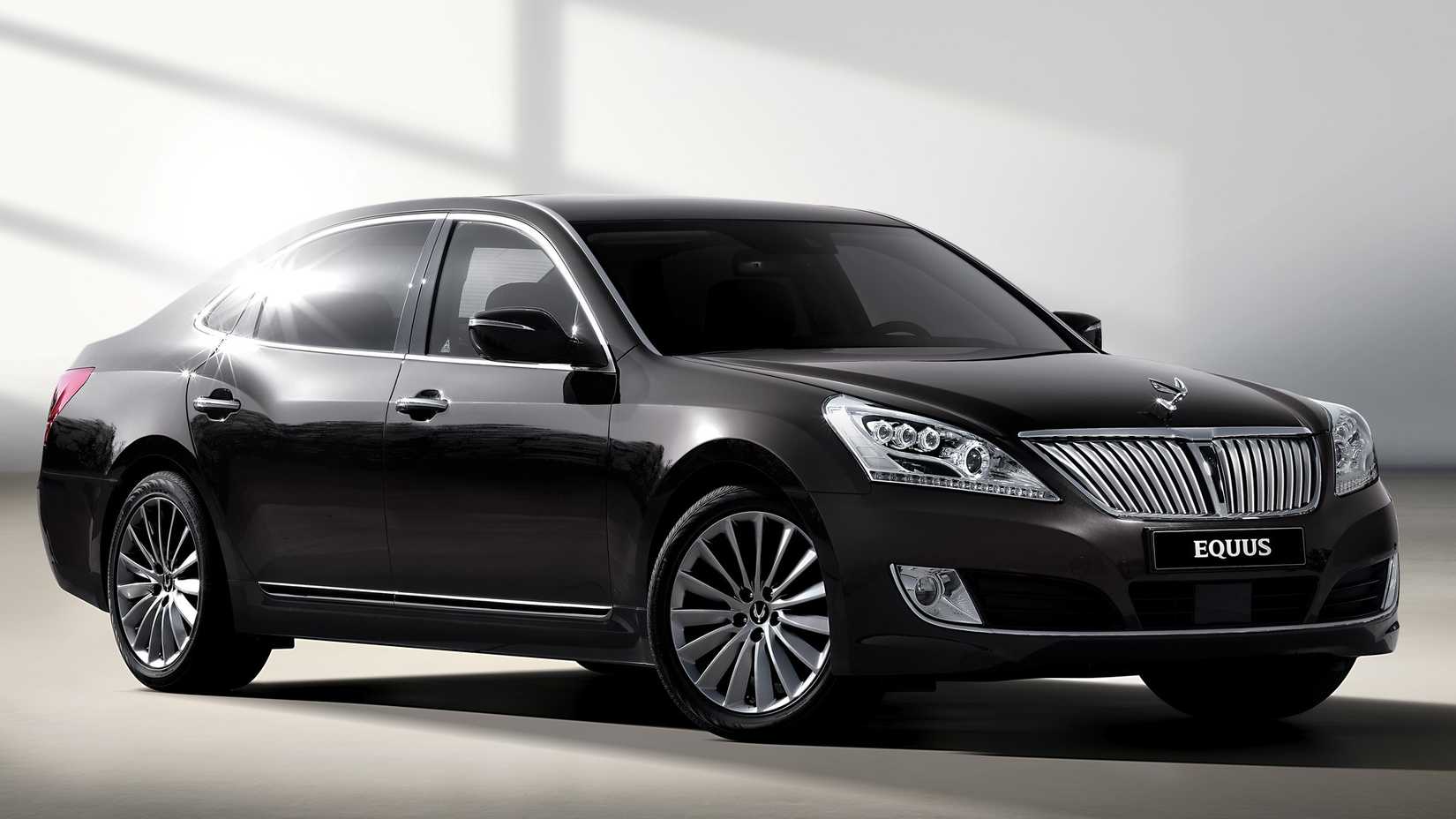 A Hyundai Equus finished in gloss-black parked in a white room.
