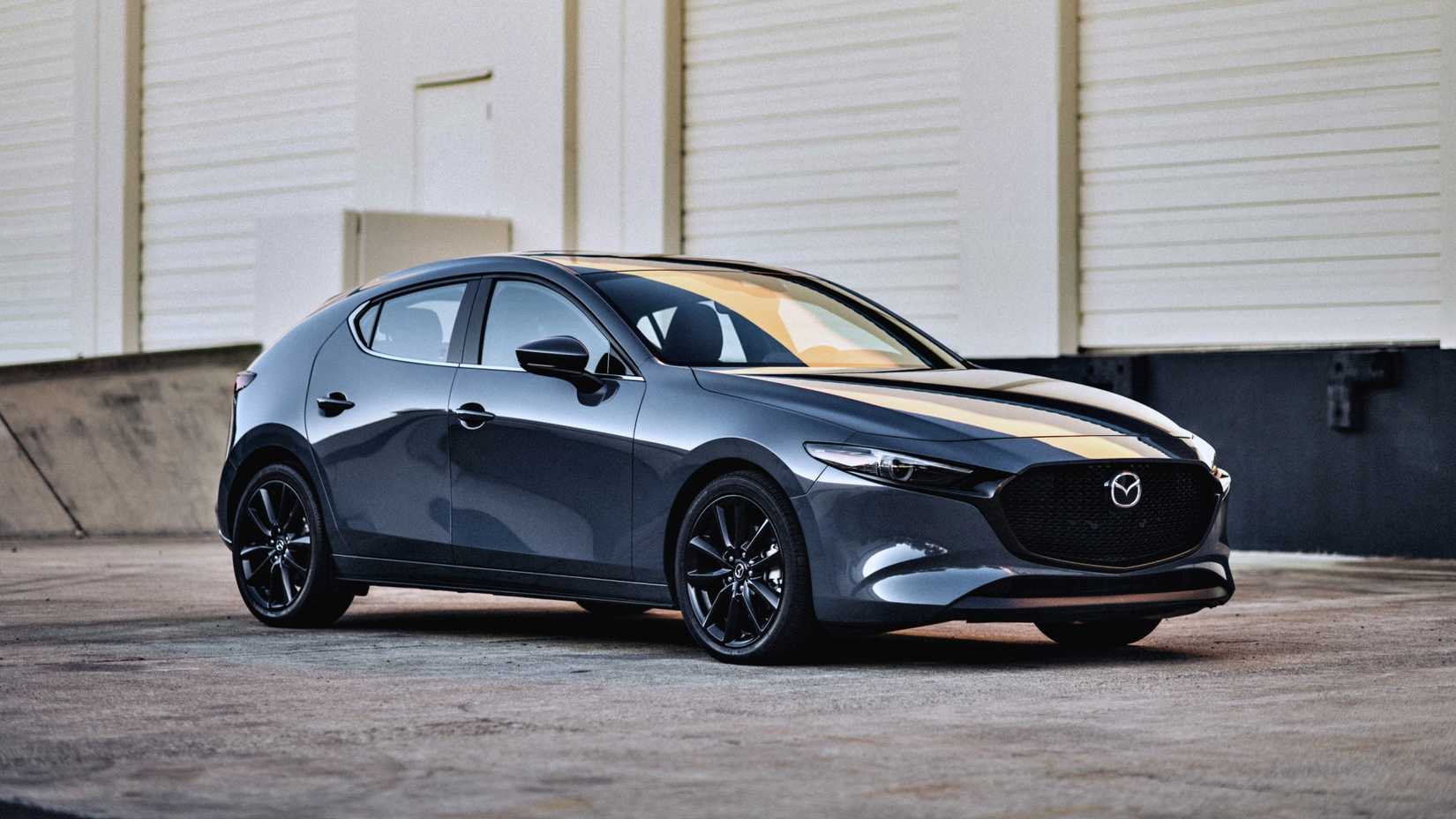 2024 Mazda 3 em cinza posando em frente ao armazém