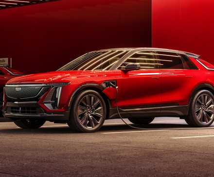 Red Cadillac Lyriq side front-quarter charging