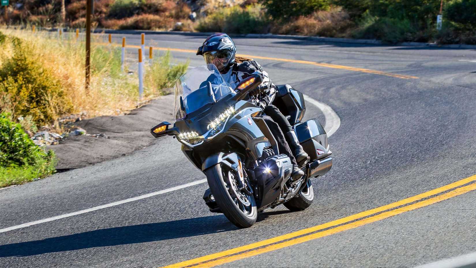 A front action shot of Honda Gold Wing Tour leaning down a corner on a highway.