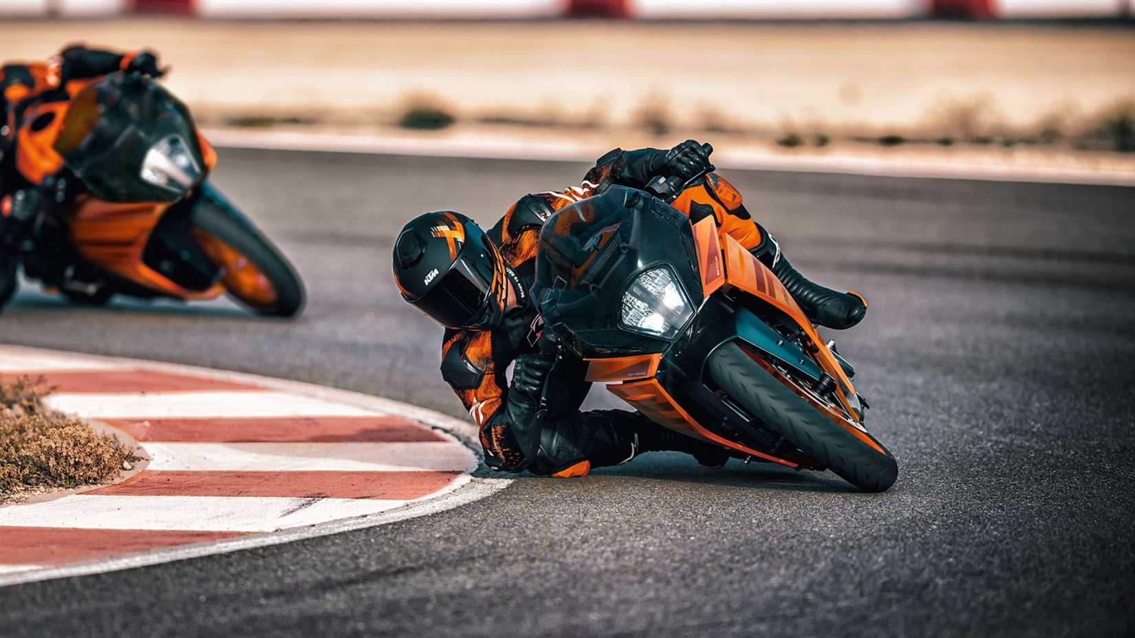 Foto de ação da KTM RC 390 supersport inclinada em uma curva da pista de corrida.
