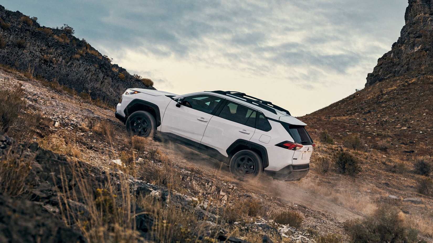 White 2024 Toyota RAV4 Hybrid climbing a hill.