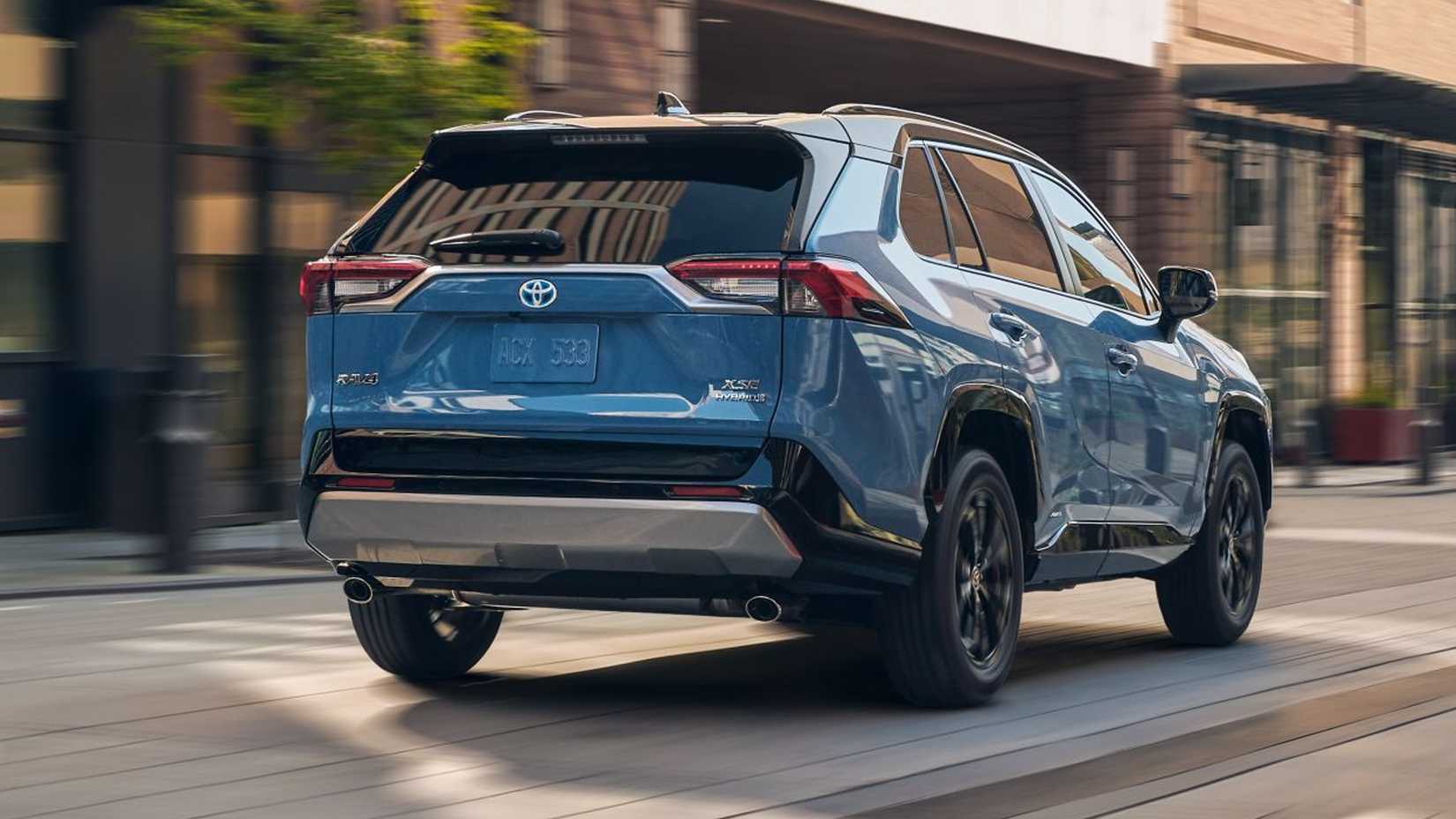 A rear 3/4 shot of the 2024 Toyota RAV4 Hybrid in the city.