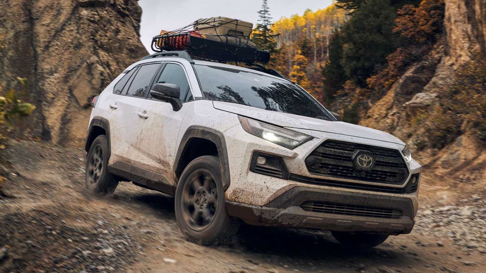 White 2024 Toyota RAV4 Hybrid coming down a hill