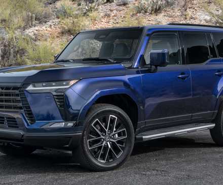 2024 Lexus GX Premium pintado Nightfall Mica. O GX está estacionado na estrada em frente a uma colina.