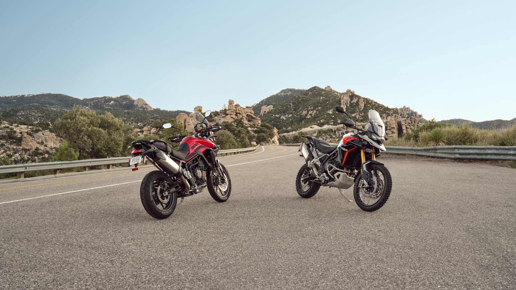 Um par de Triumph Tiger 900 Rally Pro estacionados em uma estrada de montanha