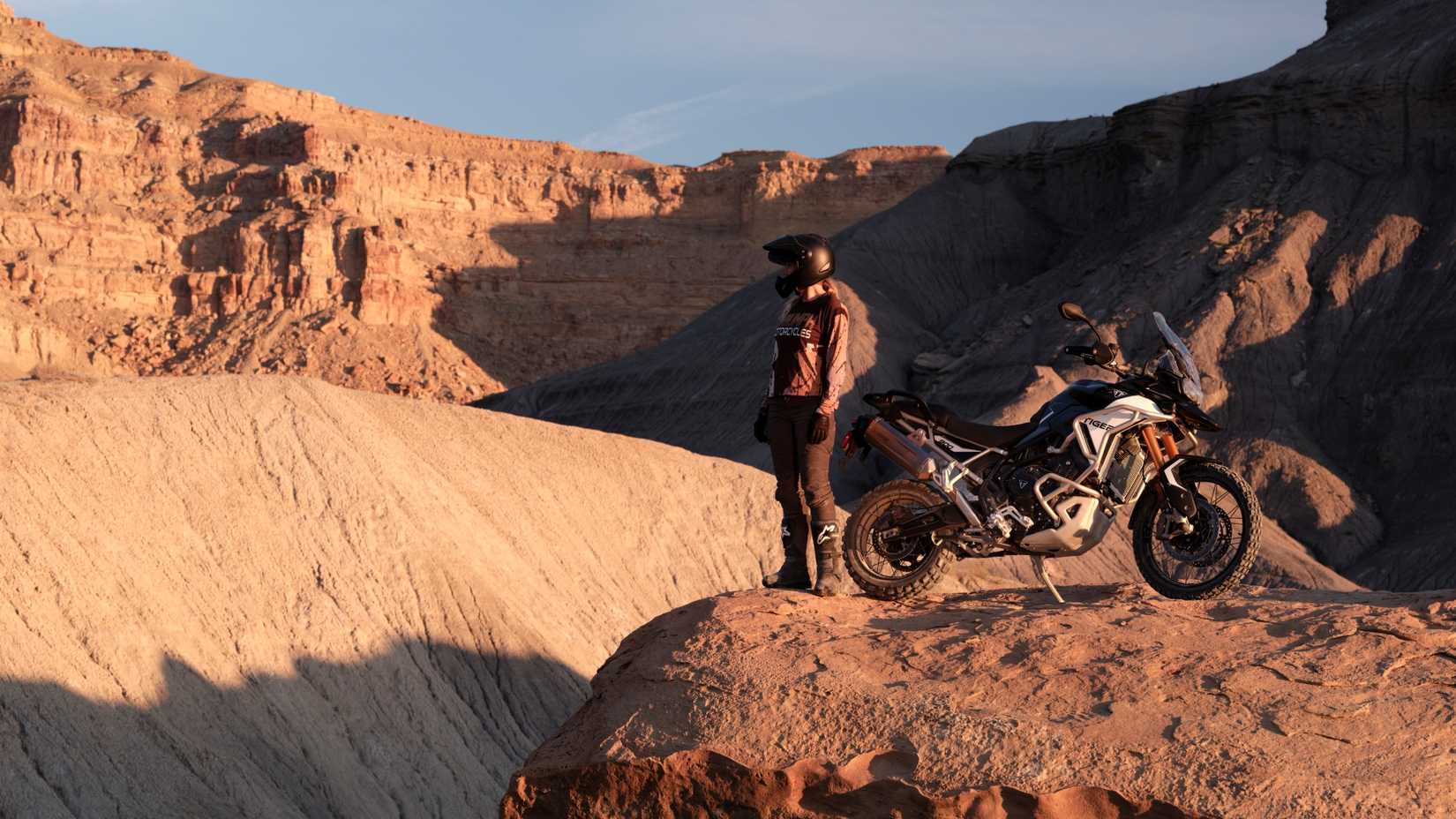 Triumph Tiger 900 Rally Pro com um piloto olhando para um penhasco