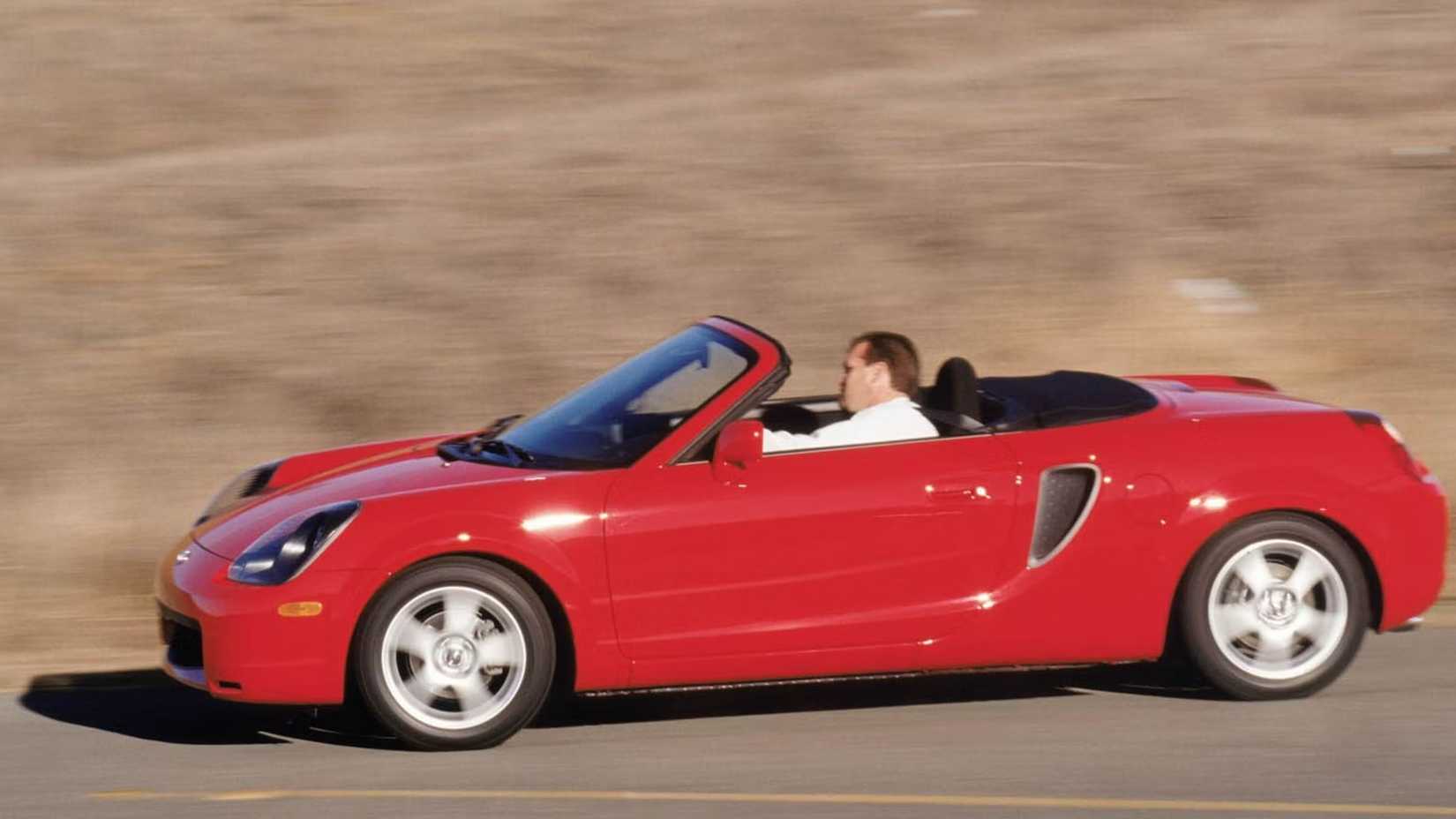 Red Toyota MR2 Spyder side shot driving on the road