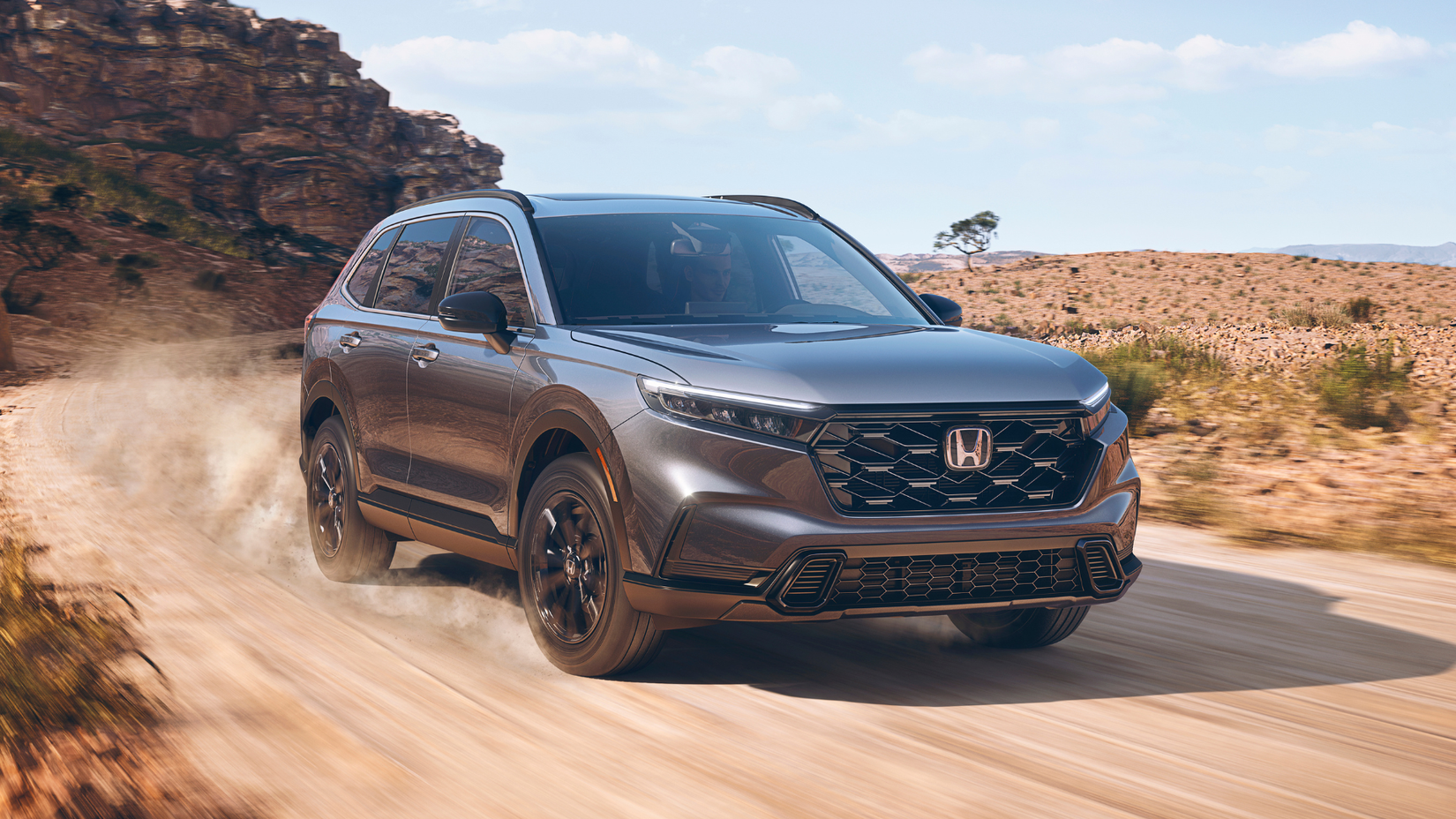 2024 Honda CR-V Hybrid Sport Touring driving on a dirt road