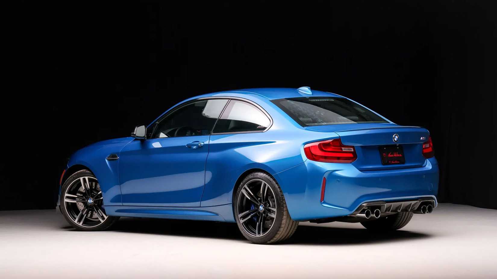 Uma vista traseira 3/4 de um BMW M2 azul 2016