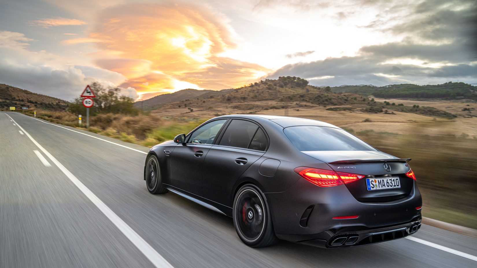 2024 Mercedes-AMG C 63 S E Performance driving down a highway at sunset