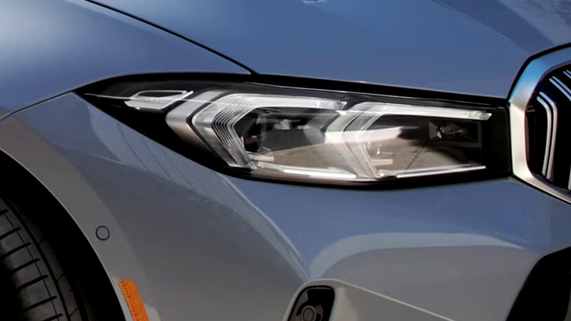 Foto externa do BMW 330i Sedan 2024 mostrando farol dianteiro de LED e pneu