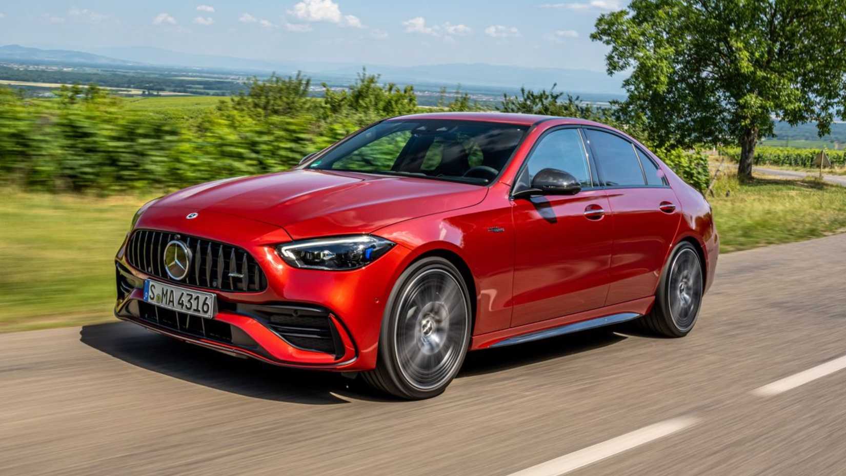 Red 2024 Mercedes-AMG C43 front 3/4 driving on winding road