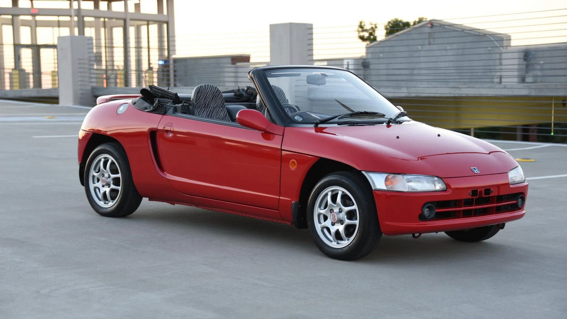 Honda Beat vermelho 1991 com capota abaixada e vista frontal 3/4