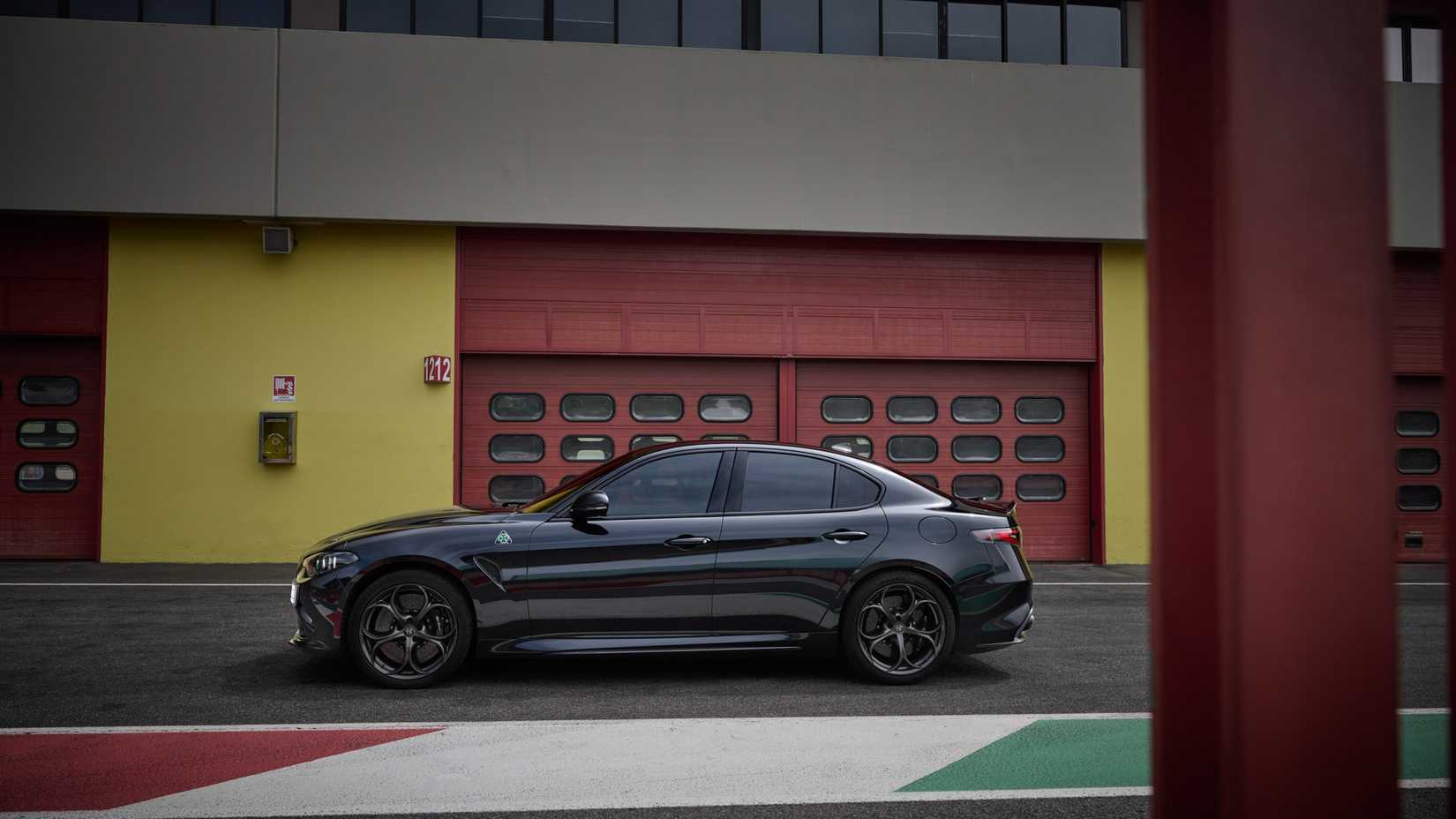 Fotografia lateral de um Alfa Romeo Giulia Super Sport 2024 estacionado em frente à garagem