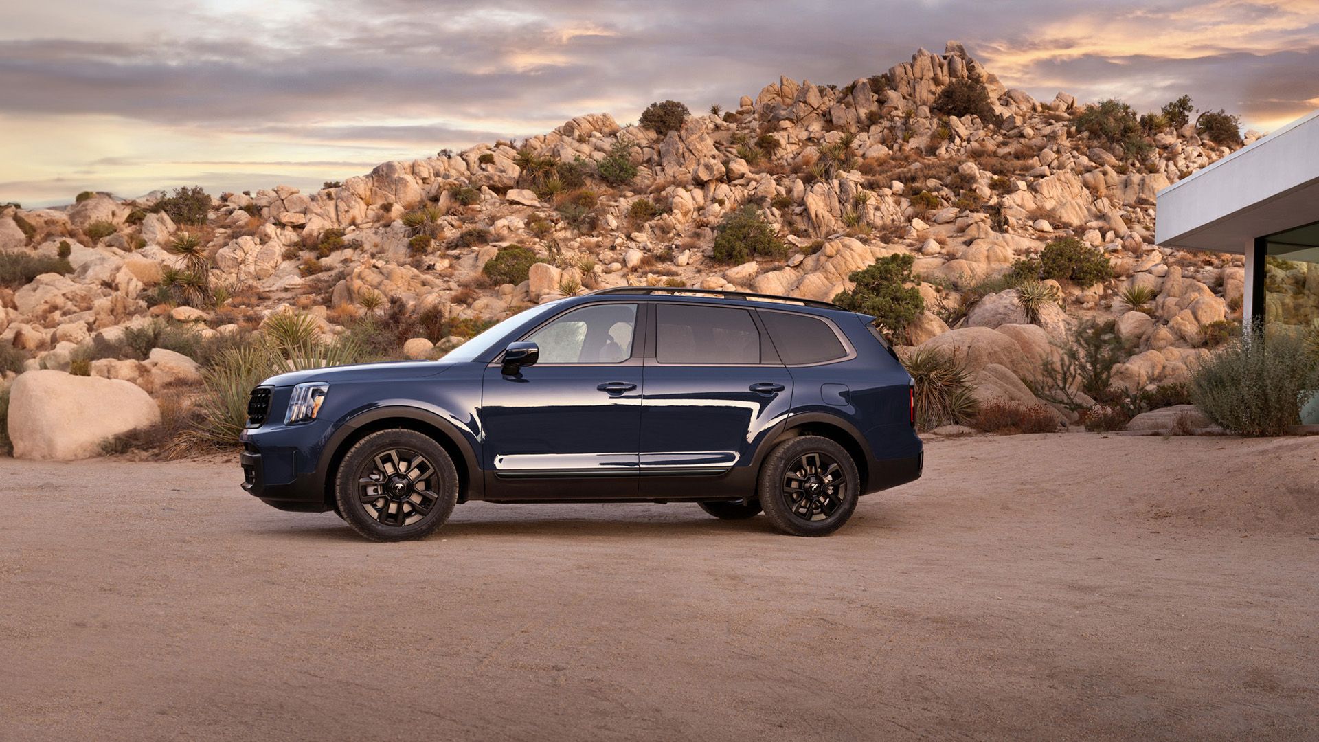 Uma foto lateral de um Kia Telluride 2024 azul estacionado