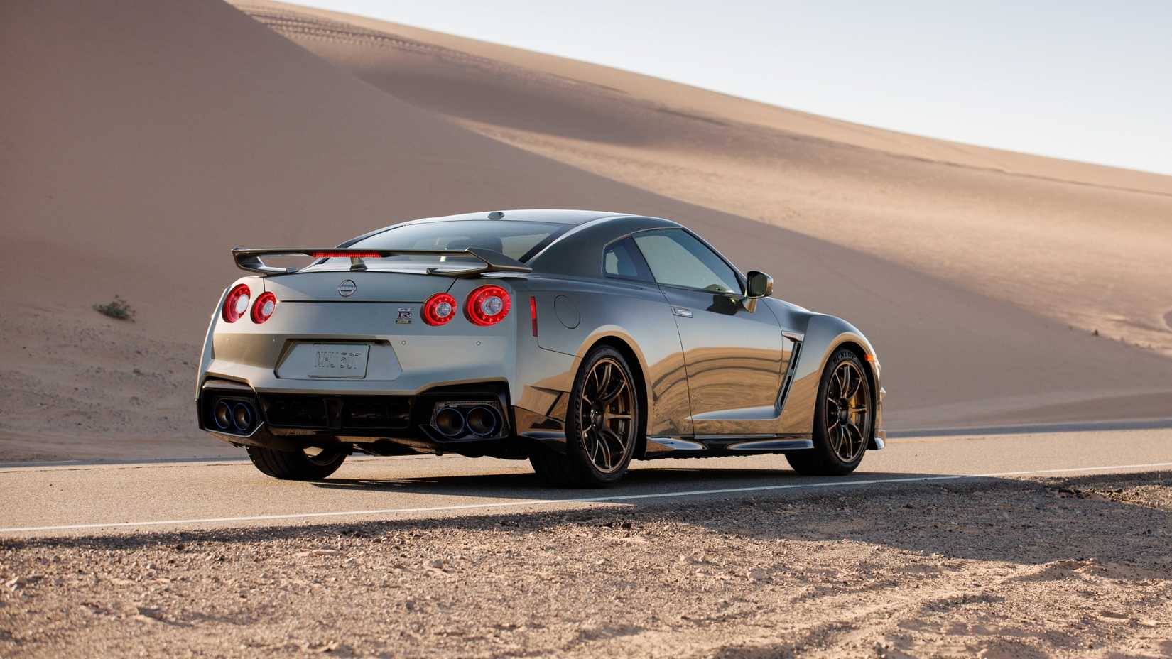 2024 Nissan GT-R T-spec rear 3/4 exterior shot on a desert road