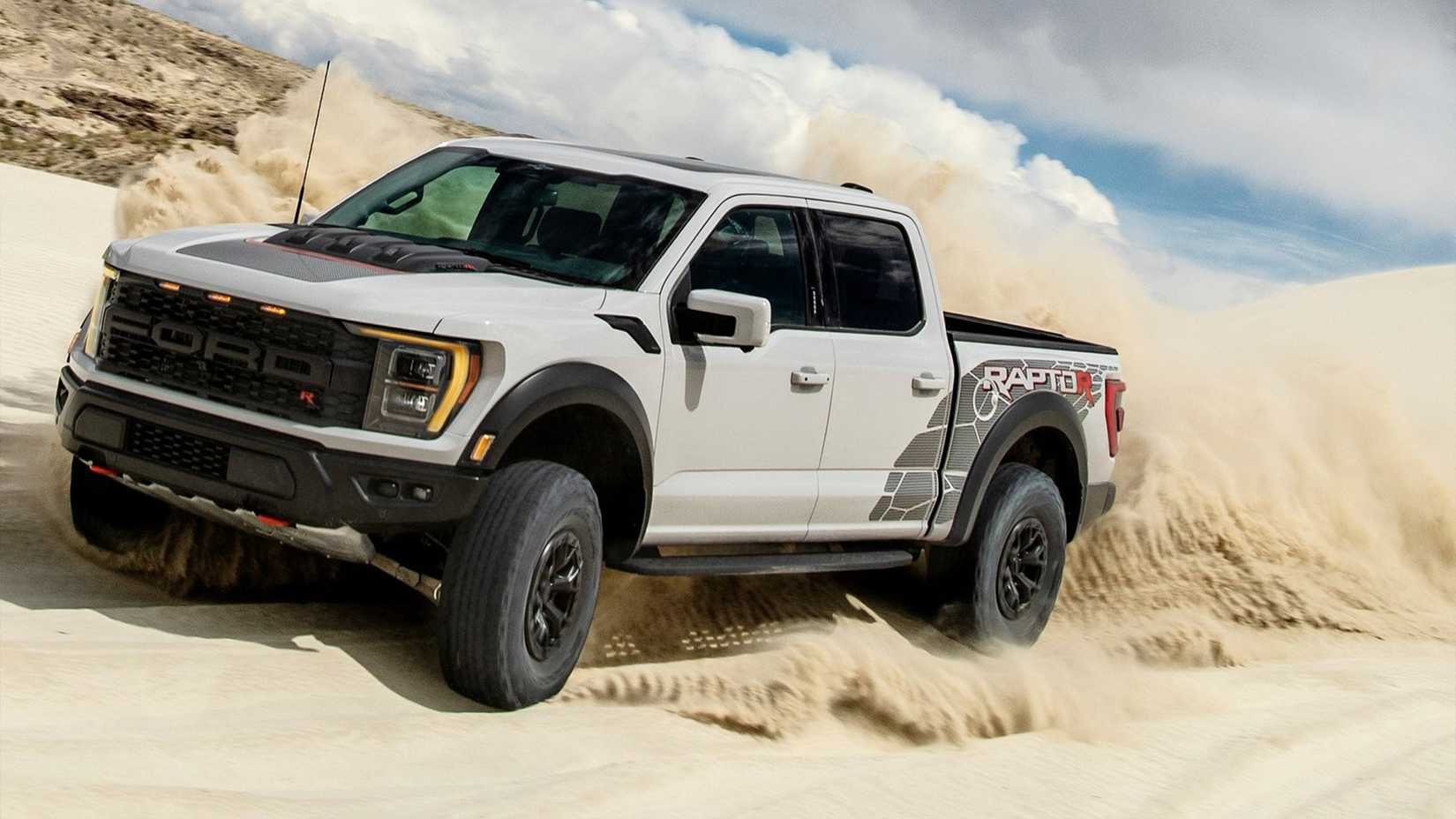 Foto frontal do Ford F-150 Raptor R branco 2023 dirigindo pelas dunas