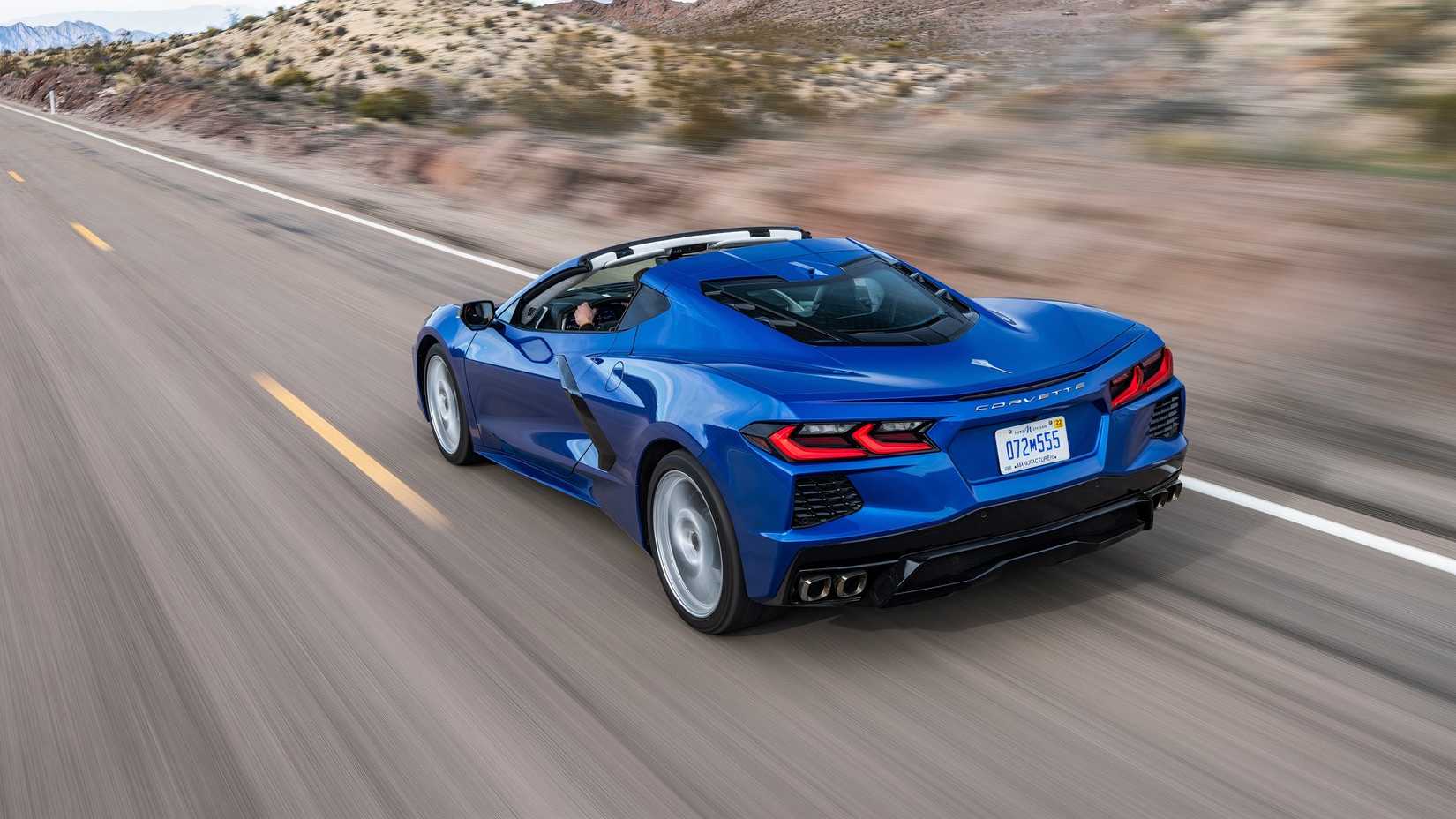 2020 Chevrolet Corvette Stingray navy blue driving on a two lane highway rear end shot