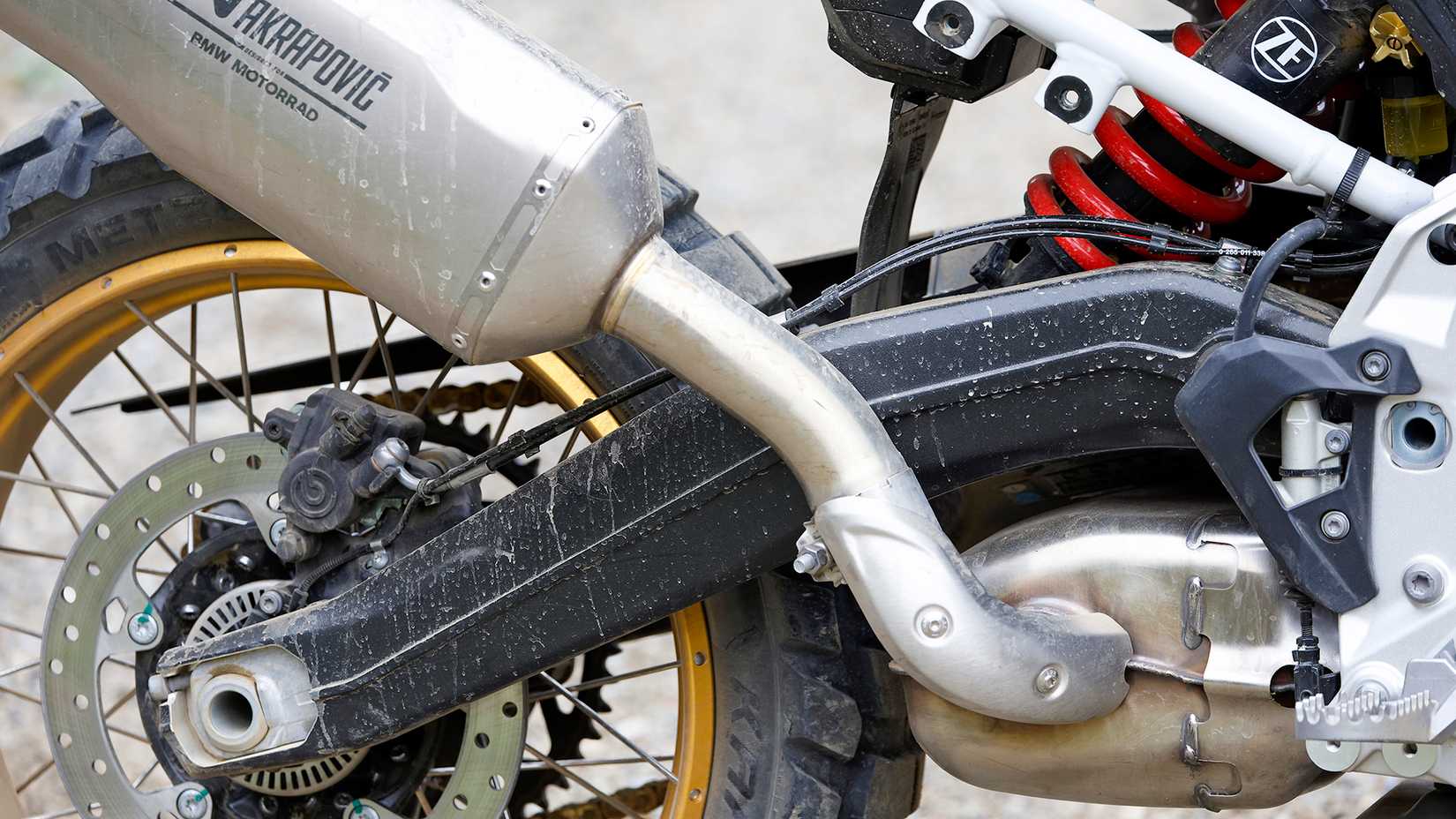 Close de um escapamento e braço oscilante BMW F 900 GS Akrapovic 2024