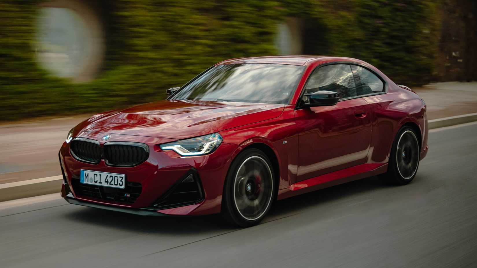 2025 BMW 2 Series front 3/4 shot driving down the road