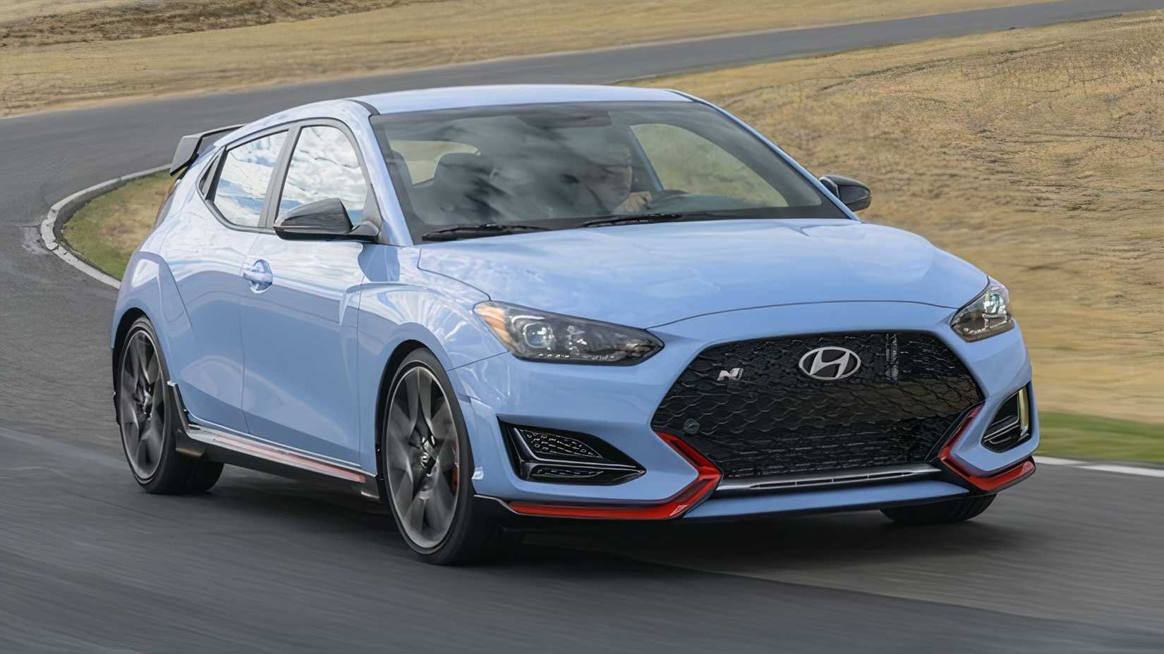 Foto frontal de ação 3/4 de um Hyundai Veloster N 2022 fazendo curva em uma estrada sinuosa