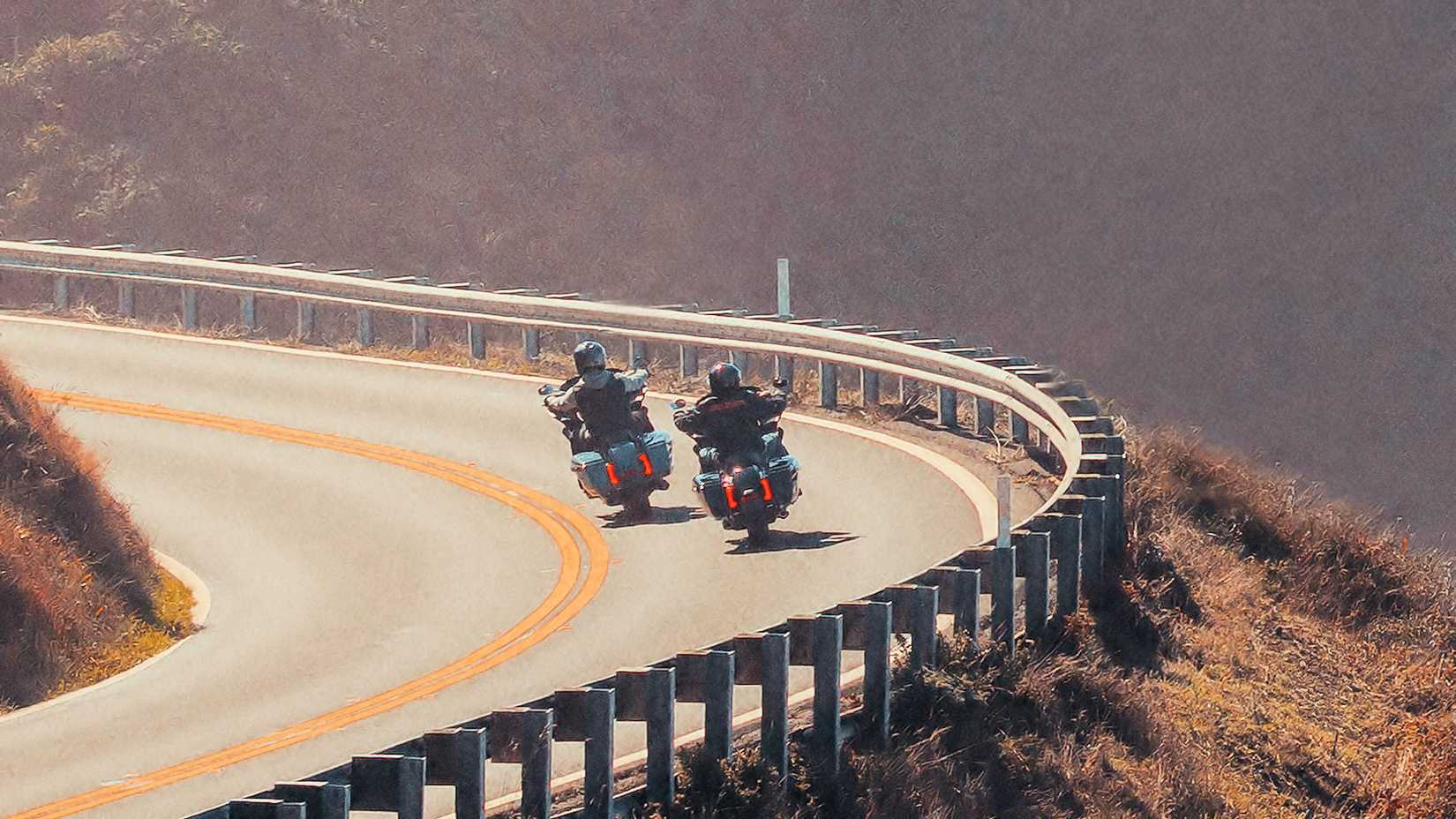 Two 2024 Harley-Davidson Street Glides cruising through a curve
