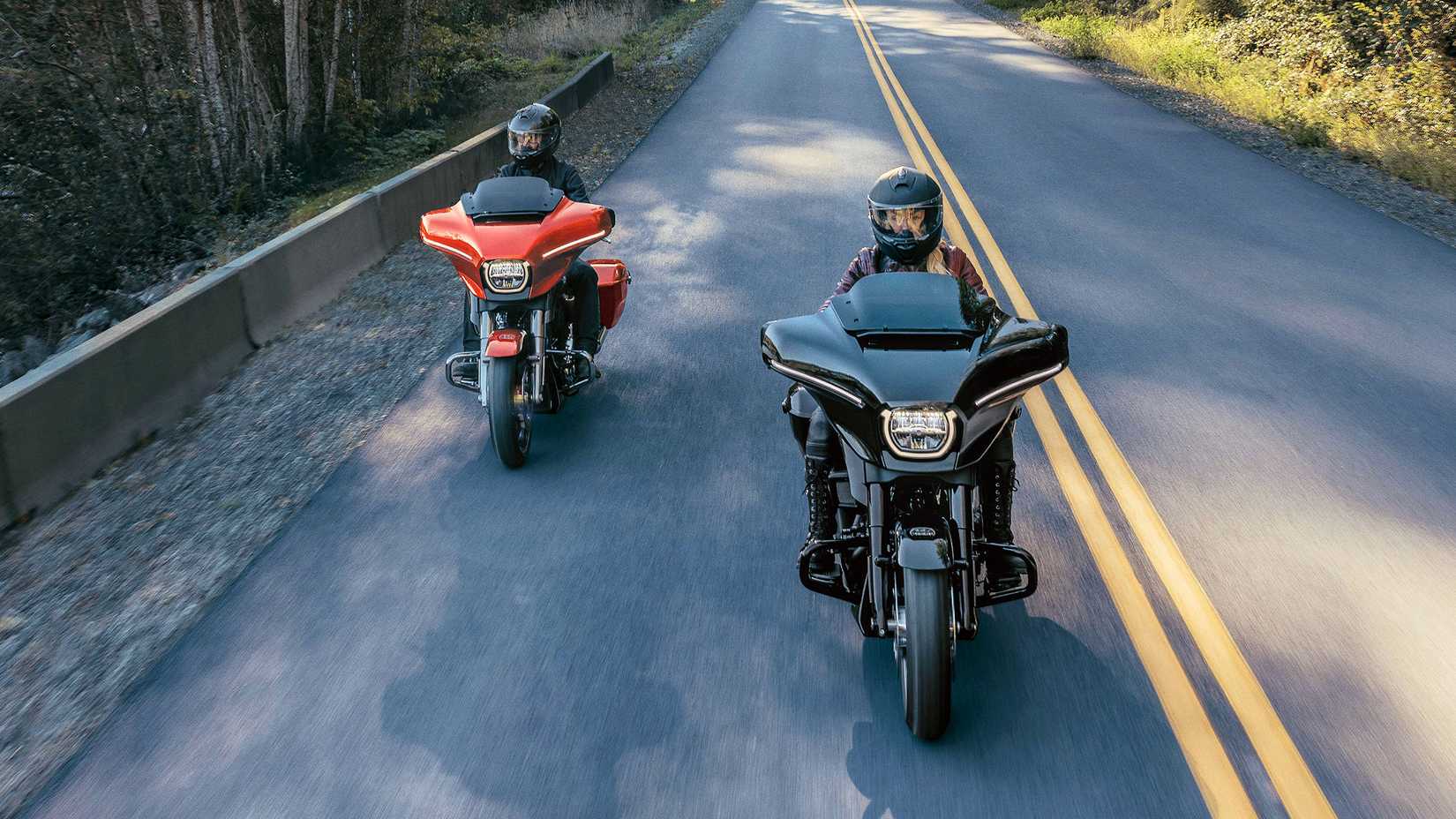 Two 2024 Harley-Davidson Street Glides cruising through the countryside