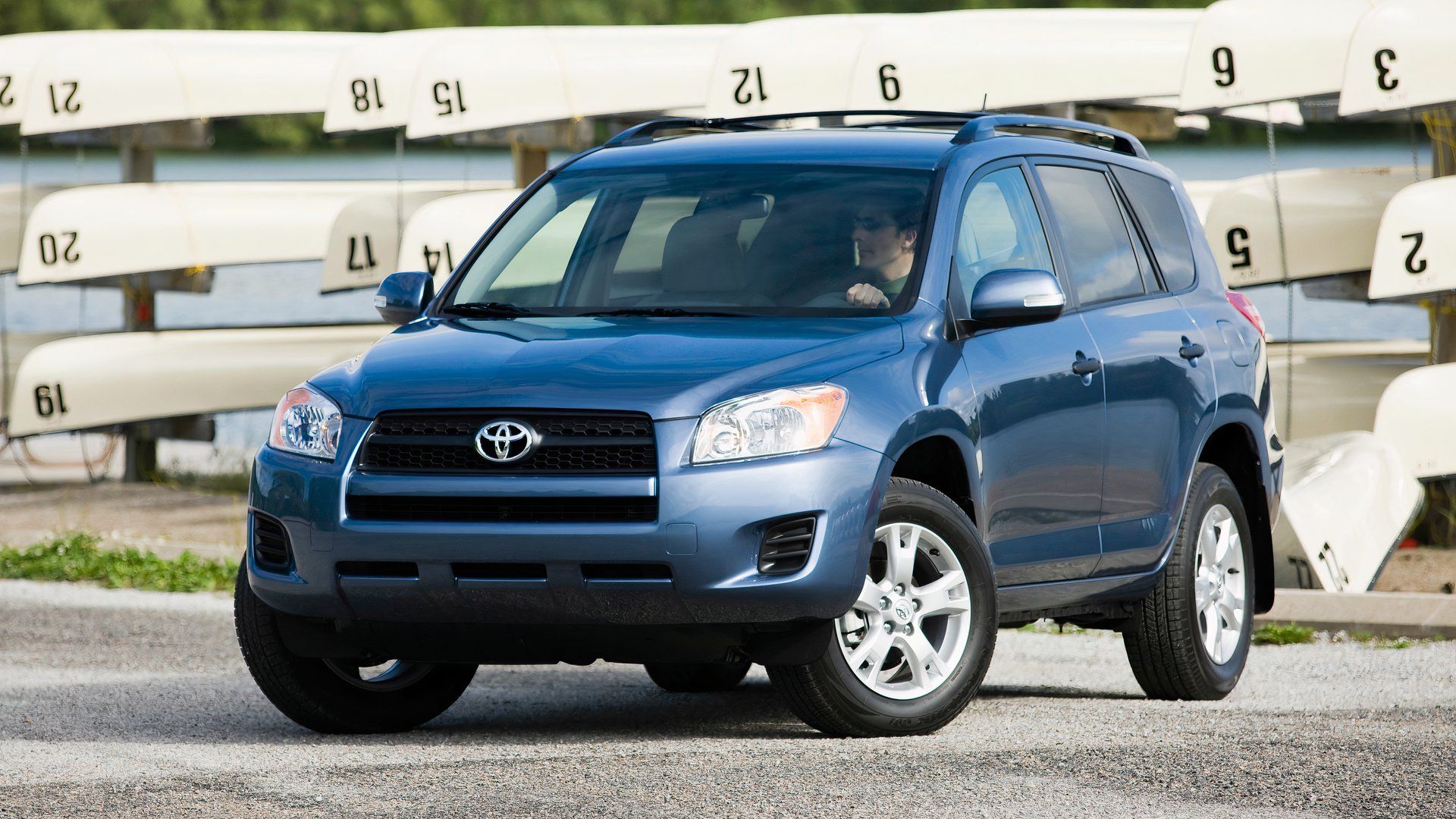 Toyota RAV4 2012 em azul Posando ao lado de canoas