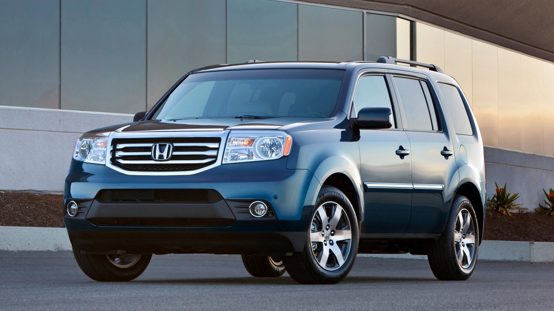 Foto frontal 3/4 de um Honda Pilot 2013 azul estacionado