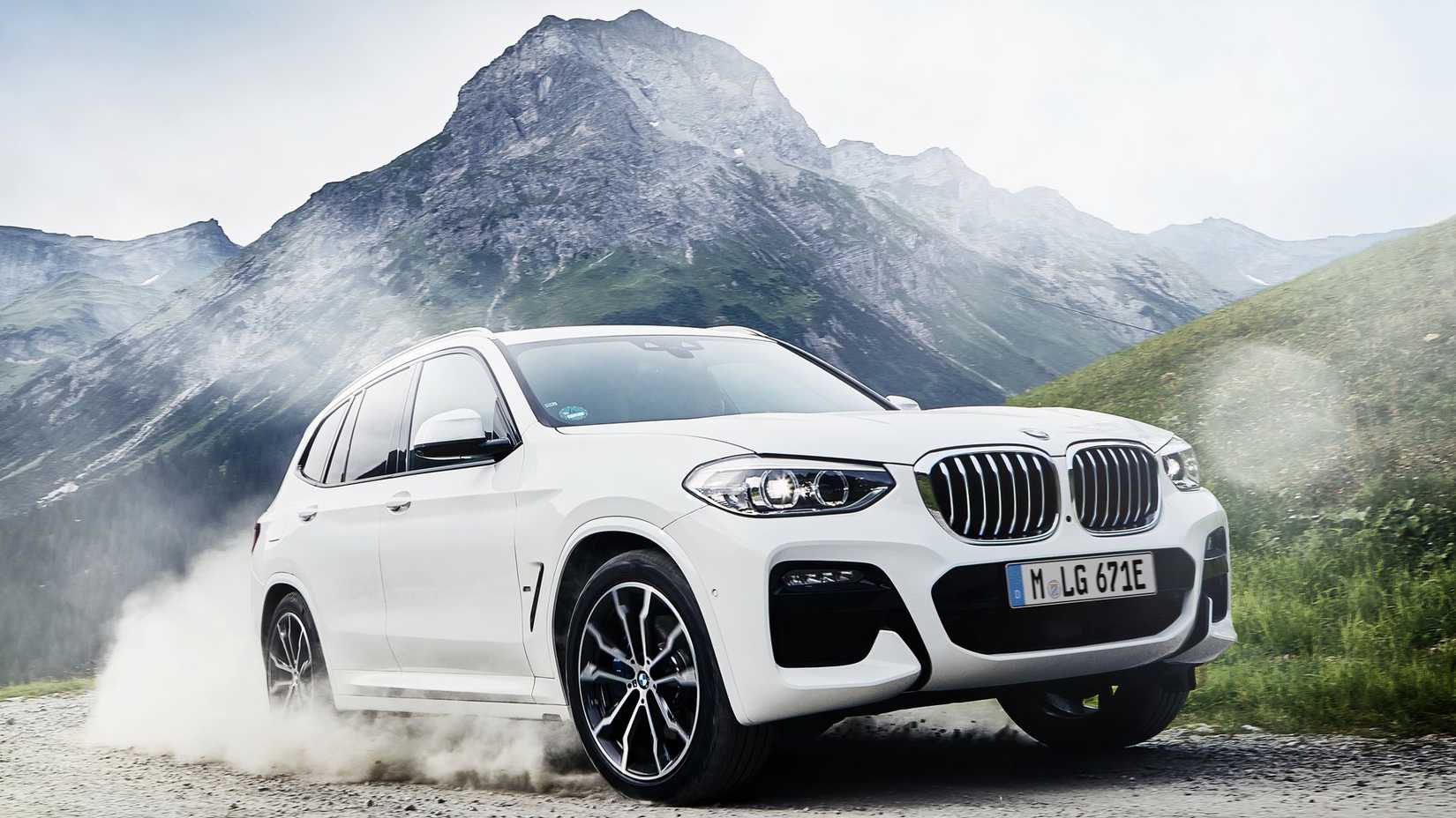 A white 2019 BMW X3 front 3/4 action shot on a dirt road