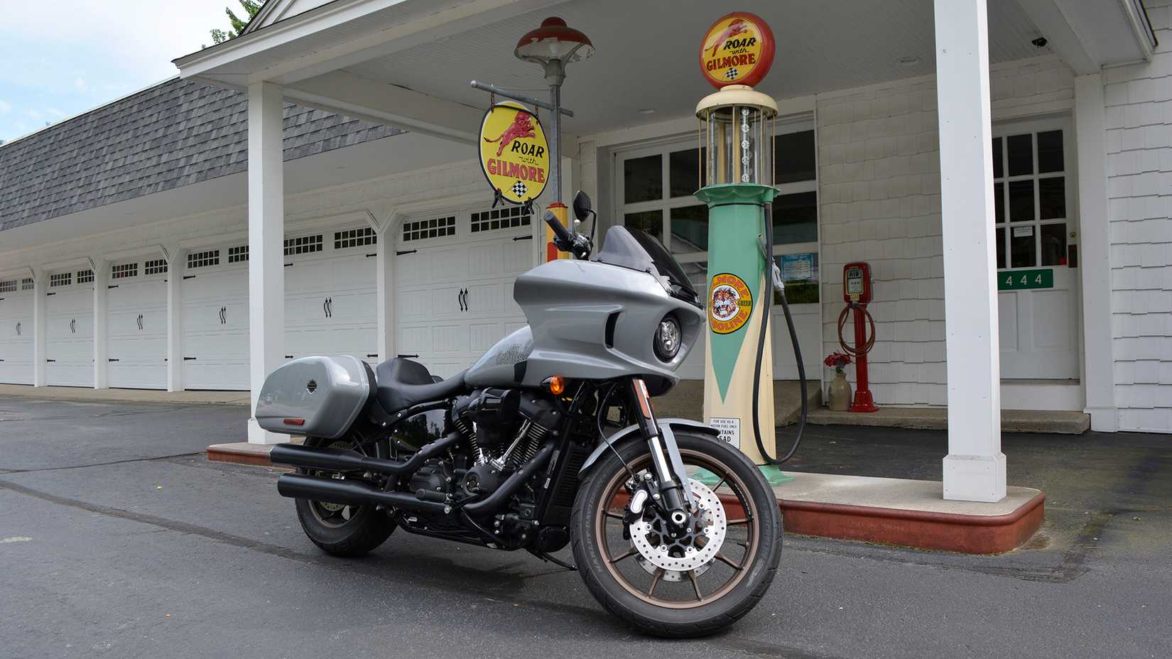 2024 Harley-Davidson Low Rider ST estacionada ao lado de um conjunto de bombas de gasolina vintage